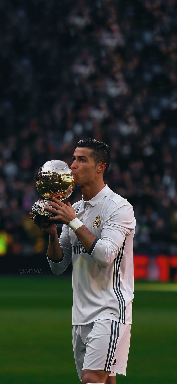 Cristiano Ronaldo kissing his 2016 Ballon d'Or trophy at the Bernabeu in a Real Madrid shirt